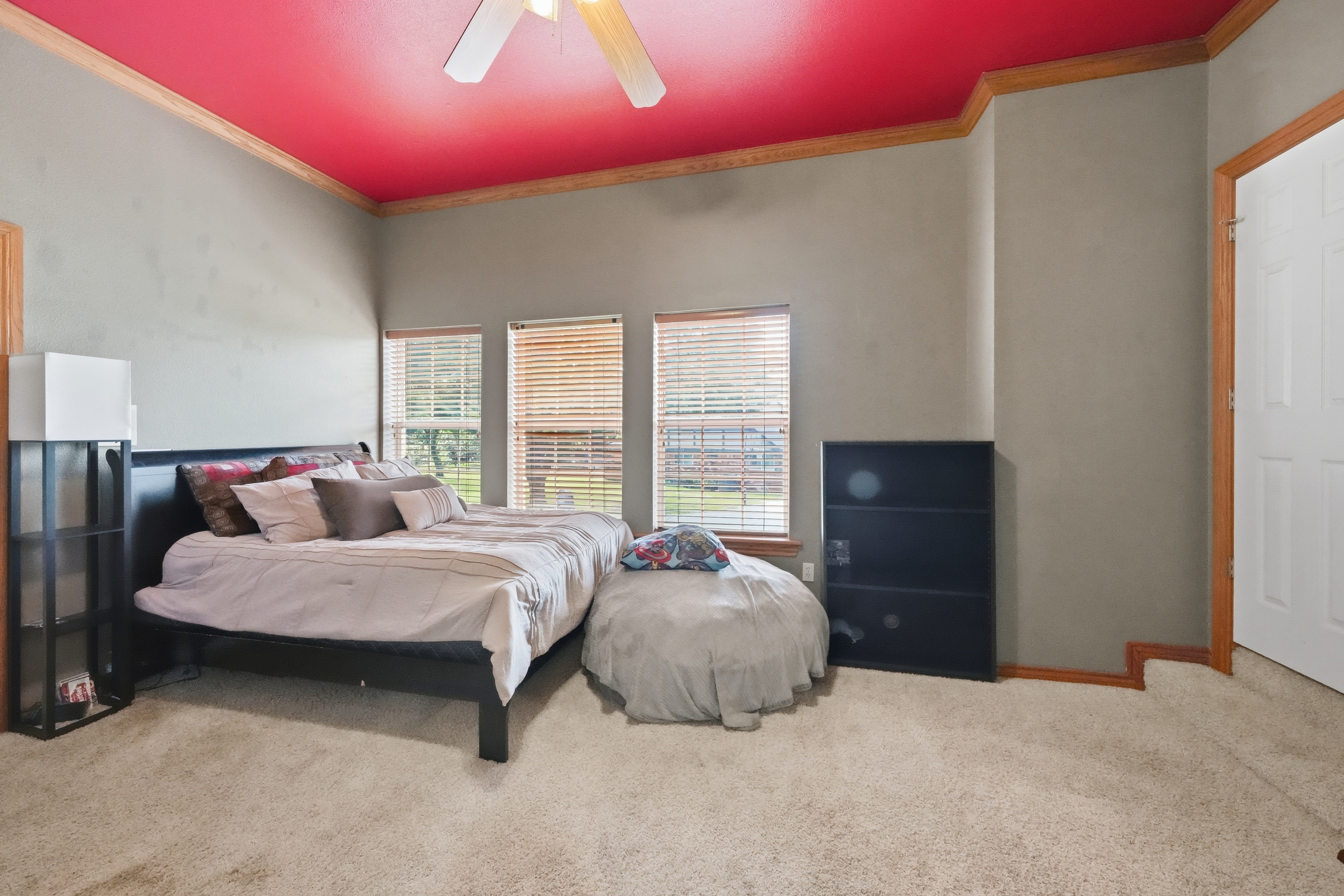 Secondary bedroom with vaulted ceiling, painted accent ceiling, and triple windows.