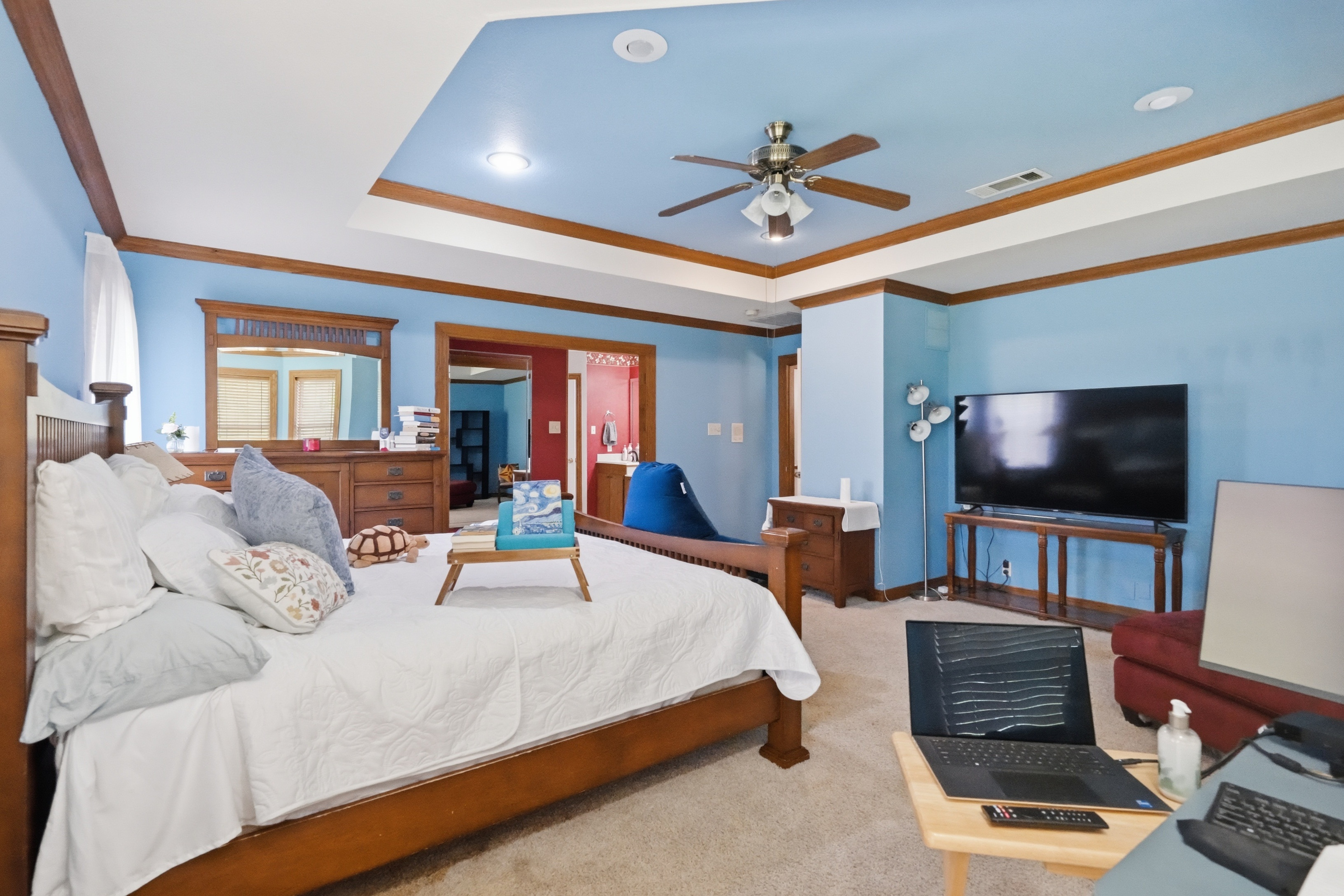 Primary bedroom showing the king bed, sitting area, and pathway to the bathroom and closet.