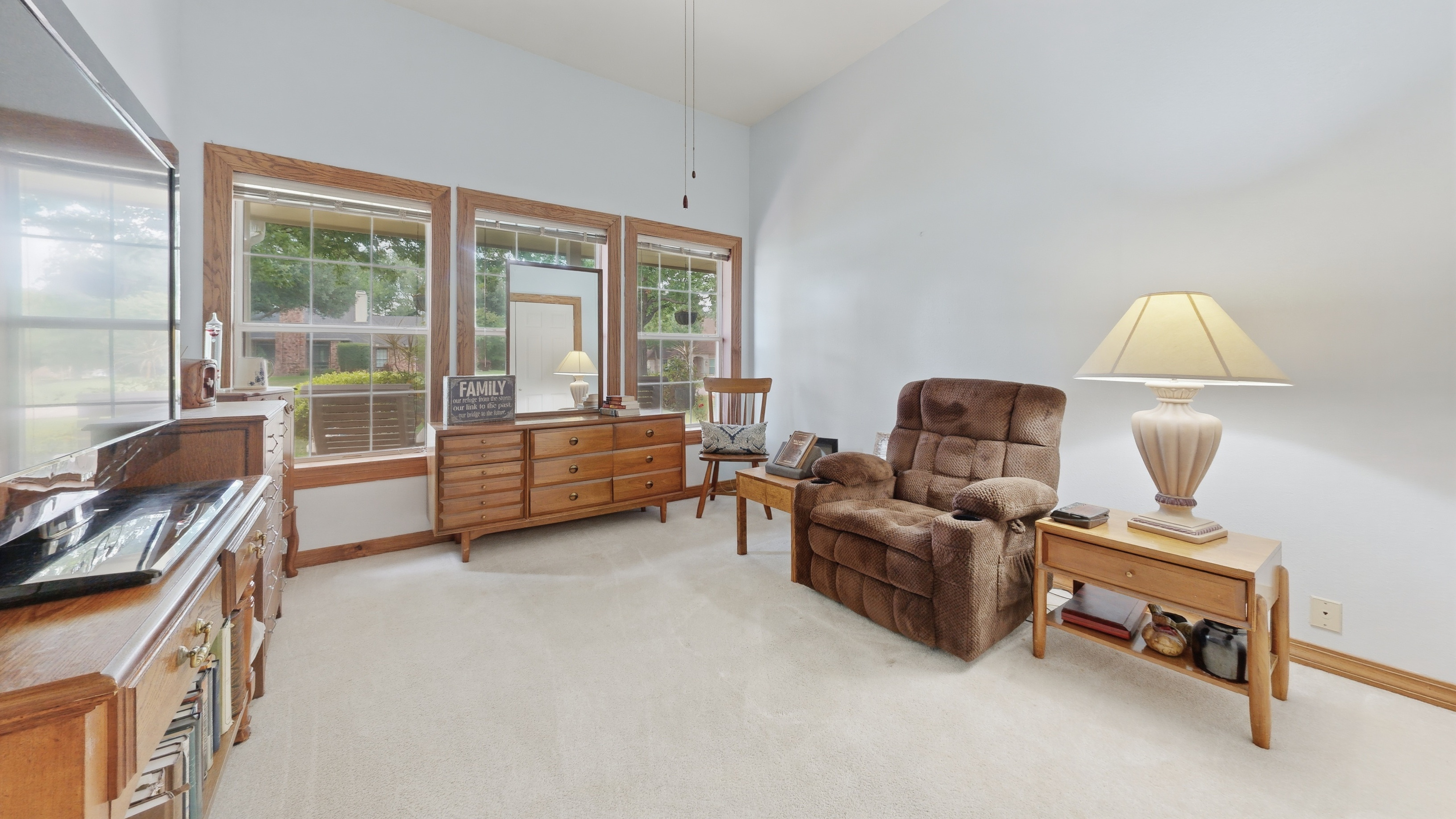 Downstairs guest bedroom with three large windows over the front yard and double-door closet.